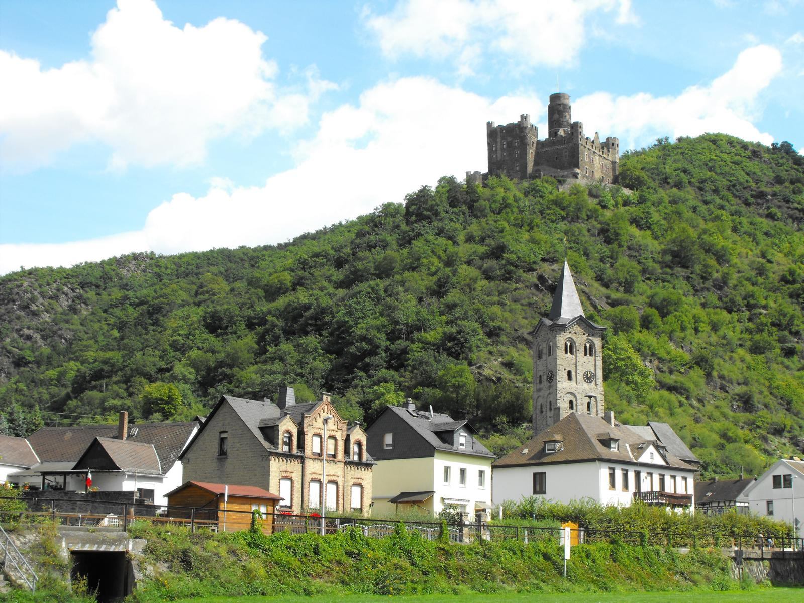 Wellmich mit dem Kirchturm von St. Martin, darüber die Burg Maus